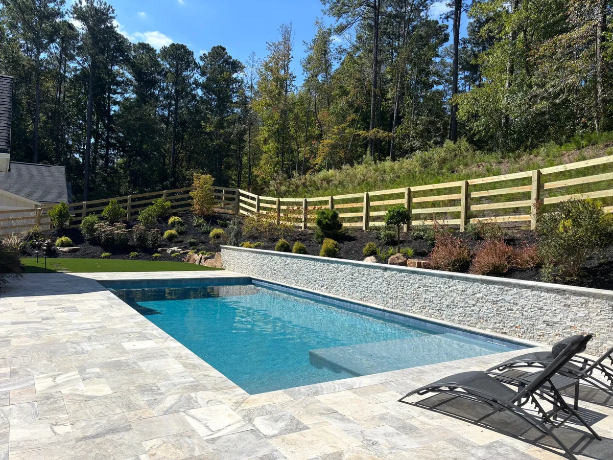 Four-board ranch rail fence with black wire along a landscaped pool area in Milton, Georgia