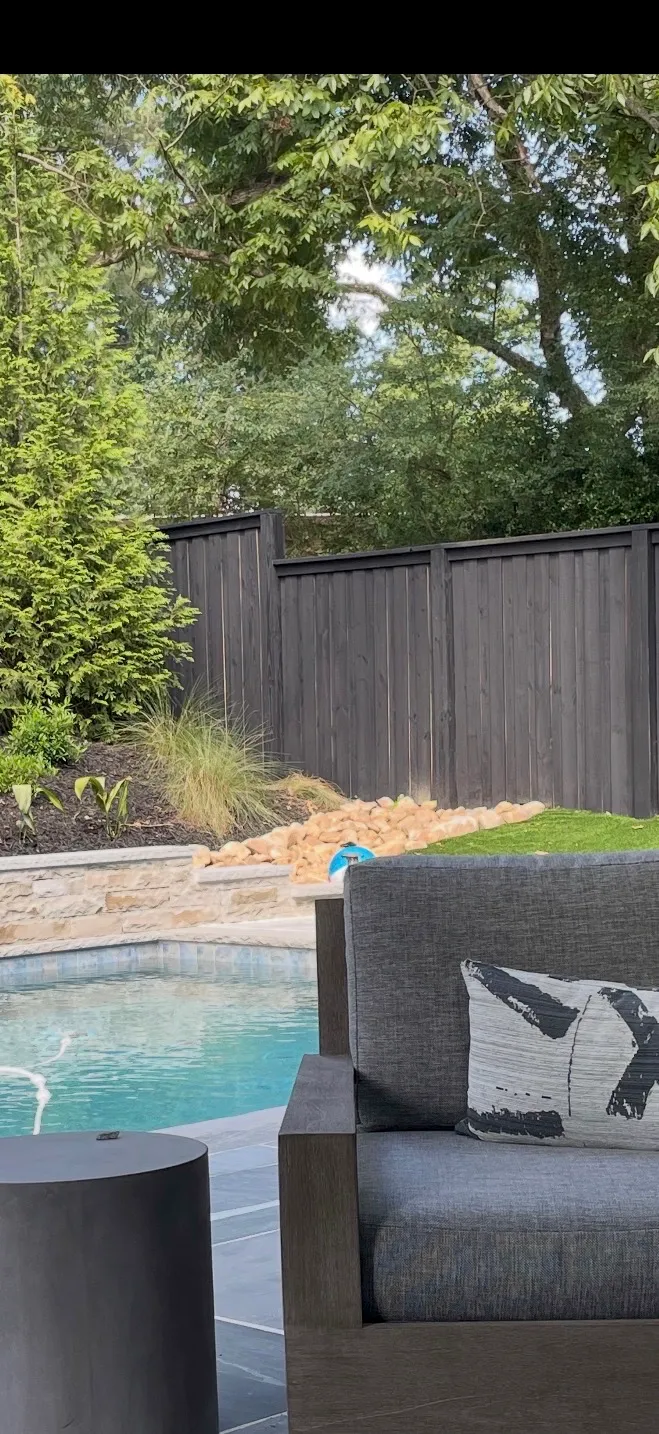 Close-up perspective of capped wood board-on-board privacy fence painted black in Alpharetta