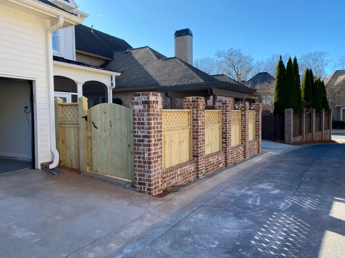 Corner perspective of lattice-top wood privacy fencing along property boundary in Alpharetta
