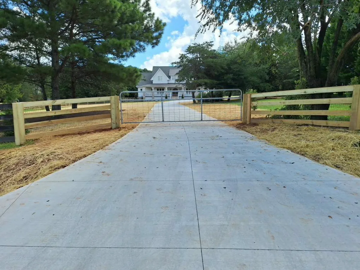 Wide double wood farm entrance gate swinging into gravel driveway in Dawsonville GA