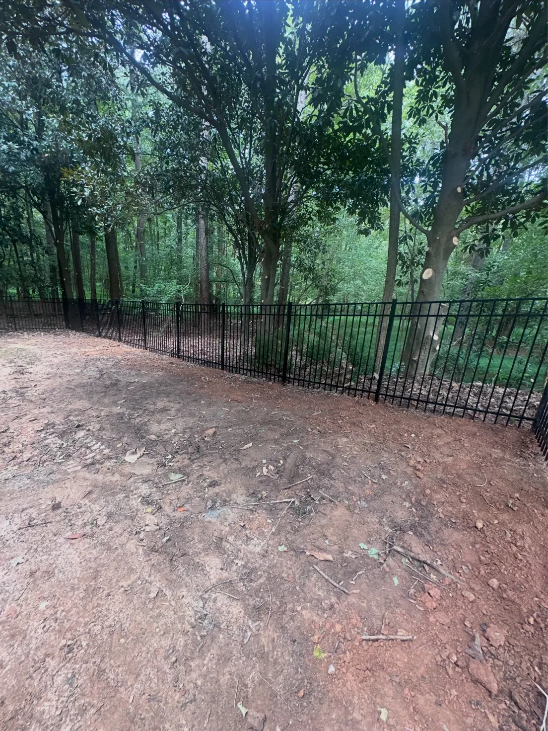 Long run of black aluminum security fence protecting backyard yard in Johns Creek